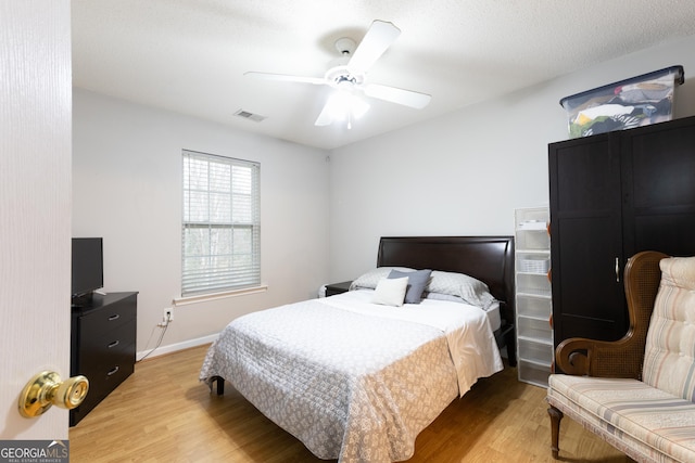 bedroom with light wood-style flooring, baseboards, visible vents, and ceiling fan