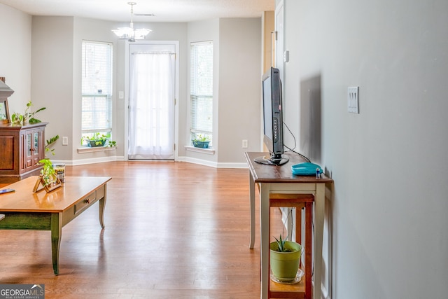 interior space featuring a chandelier, baseboards, and wood finished floors