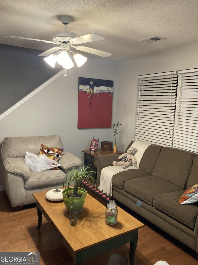 living room with ceiling fan, hardwood / wood-style floors, and a textured ceiling