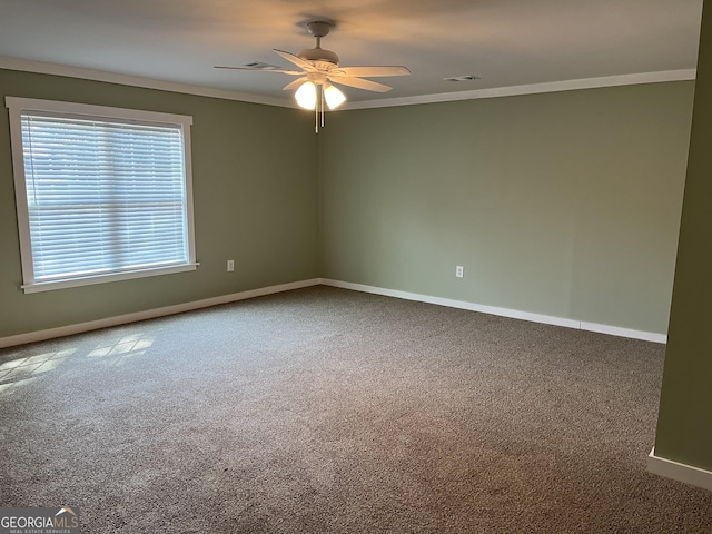 empty room with ornamental molding, carpet flooring, and ceiling fan