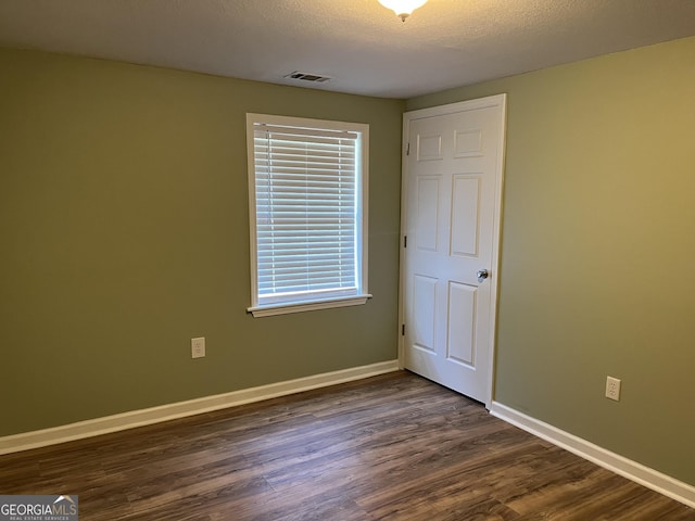 unfurnished bedroom featuring dark hardwood / wood-style floors and a textured ceiling