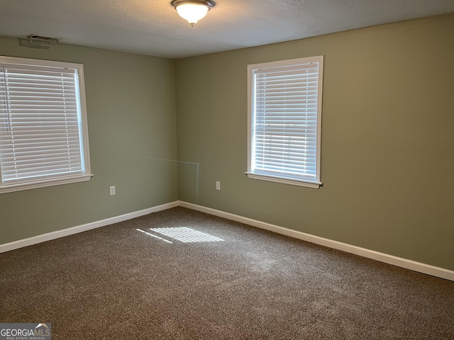 carpeted spare room with a textured ceiling