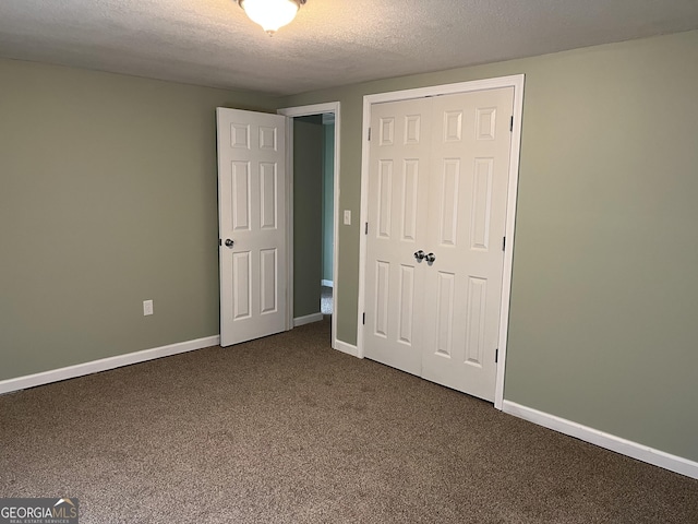 unfurnished bedroom with carpet flooring, a textured ceiling, and a closet