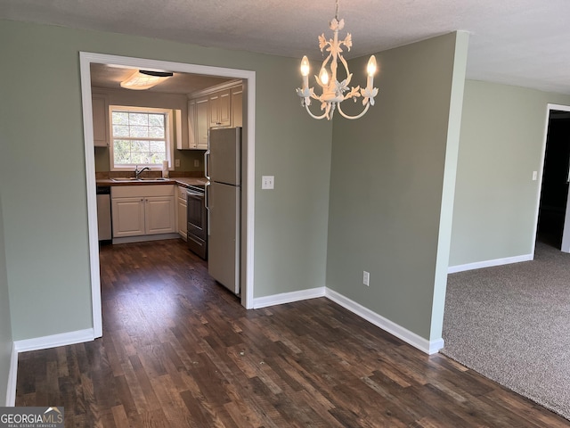 kitchen with sink, an inviting chandelier, hanging light fixtures, white refrigerator, and stainless steel range with electric cooktop