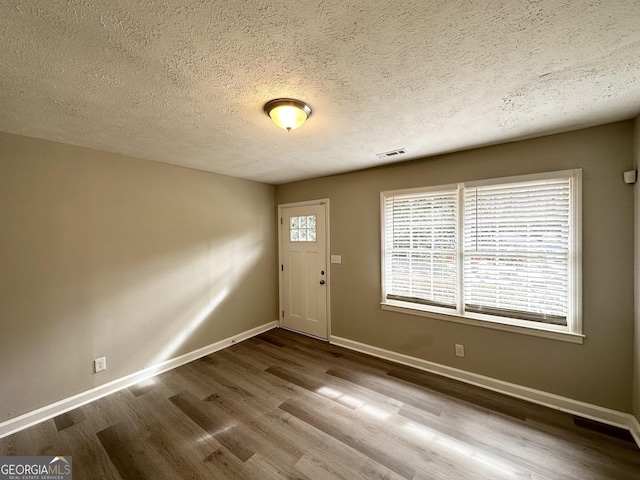 foyer entrance featuring hardwood / wood-style floors and a textured ceiling