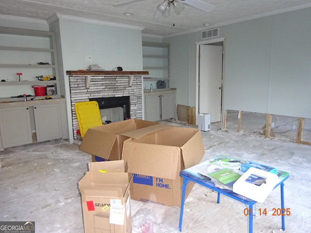 living room featuring crown molding, ceiling fan, and a stone fireplace