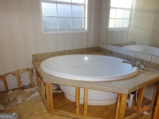 bathroom featuring a relaxing tiled tub