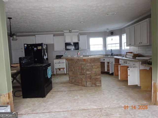 kitchen featuring sink, white cabinets, a center island, black appliances, and a textured ceiling