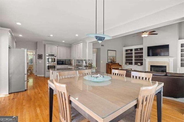 dining area with ceiling fan and light hardwood / wood-style floors