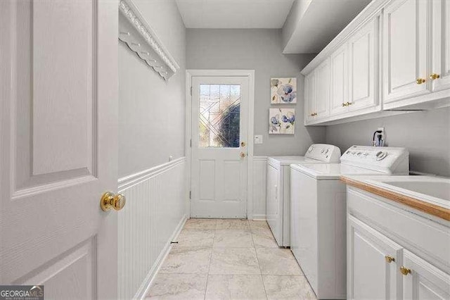 washroom with washer and dryer, light tile patterned floors, and cabinets