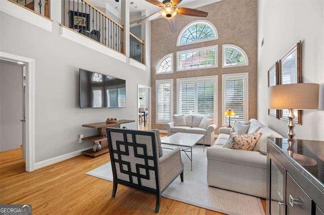 living room featuring ceiling fan, plenty of natural light, and light wood-type flooring