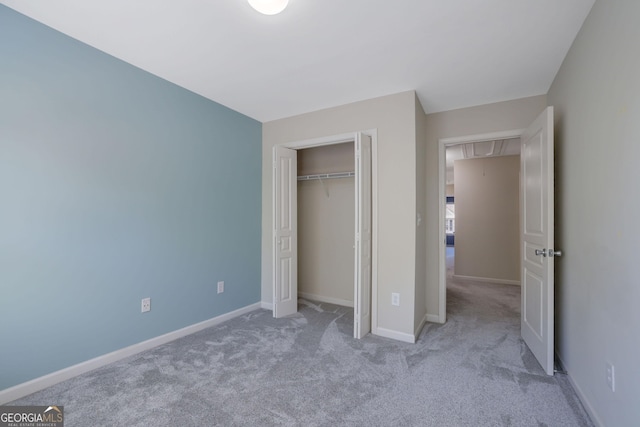 unfurnished bedroom with a closet and light colored carpet