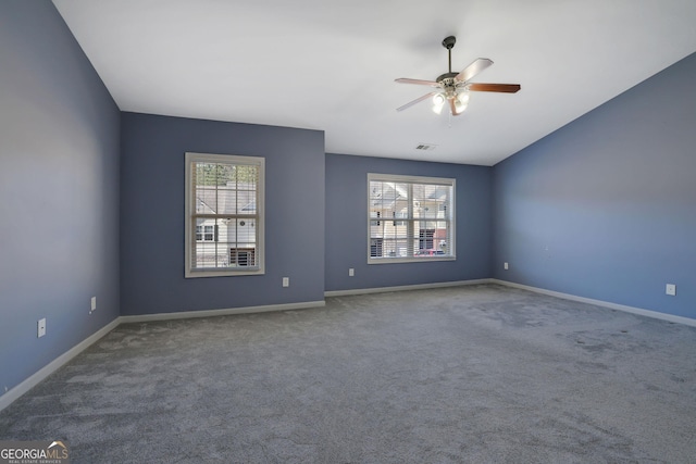 spare room featuring carpet floors, ceiling fan, vaulted ceiling, and plenty of natural light