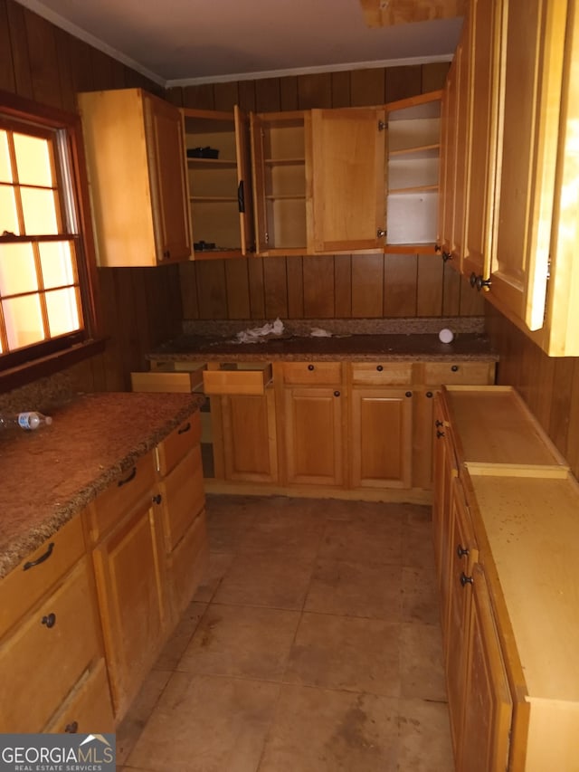 kitchen with light stone counters, crown molding, and wooden walls