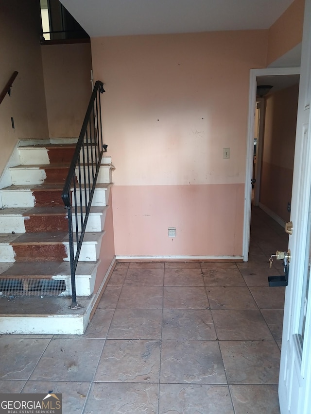 stairway with tile patterned floors