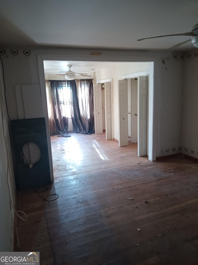 empty room with ceiling fan and hardwood / wood-style floors