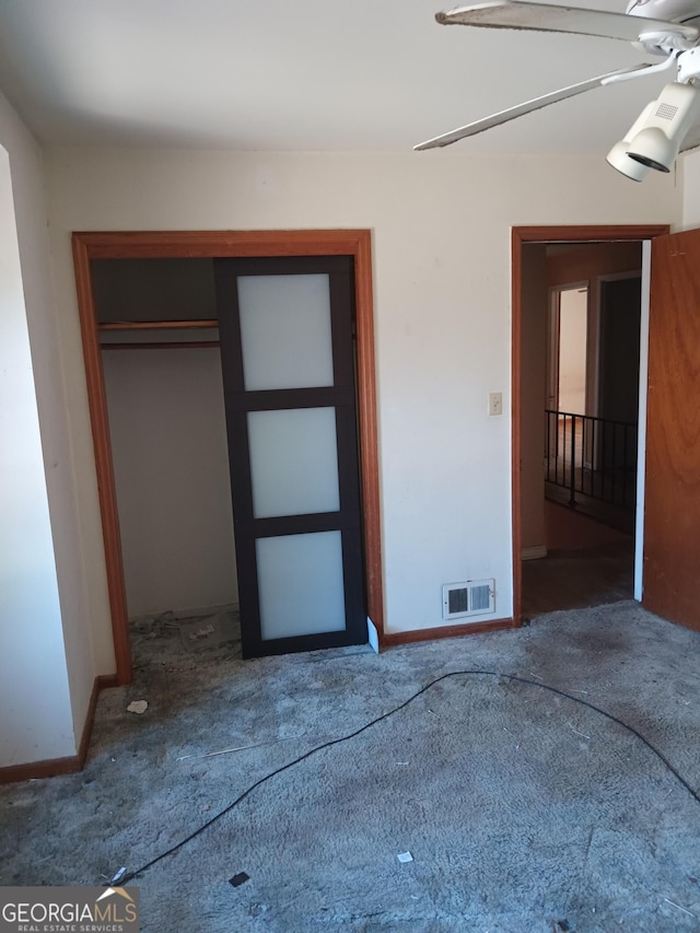 unfurnished bedroom with dark colored carpet and a closet