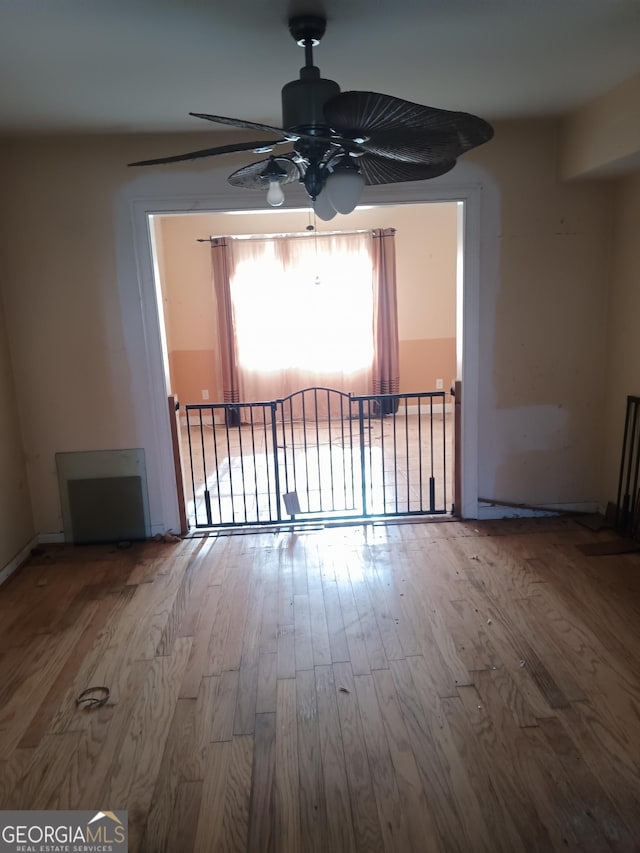 unfurnished room with hardwood / wood-style floors and ceiling fan