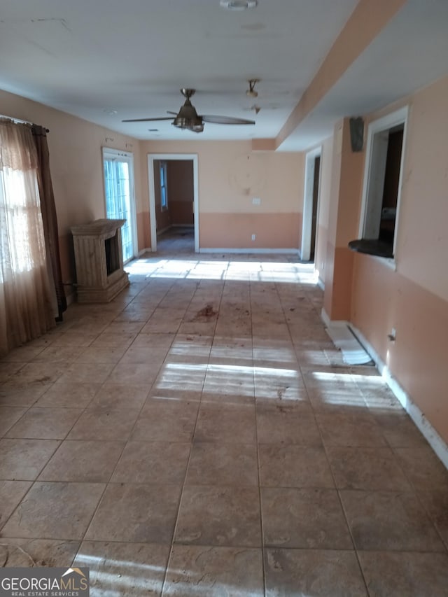 unfurnished room with light tile patterned floors and ceiling fan