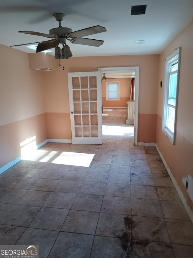 unfurnished room with ceiling fan and plenty of natural light