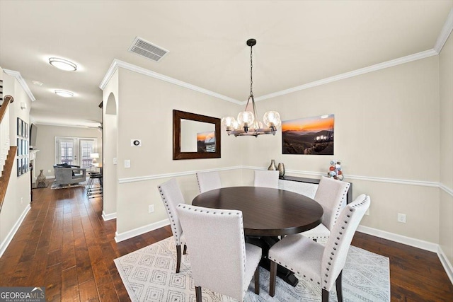 dining area featuring dark wood-type flooring, ornamental molding, and a chandelier