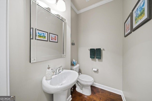 bathroom with sink, crown molding, hardwood / wood-style floors, and toilet