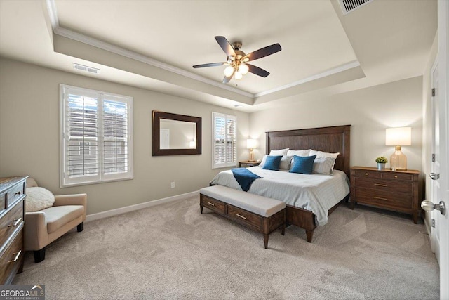 carpeted bedroom with ceiling fan, ornamental molding, and a raised ceiling