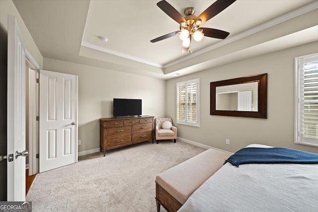 carpeted bedroom featuring crown molding, ceiling fan, and a raised ceiling