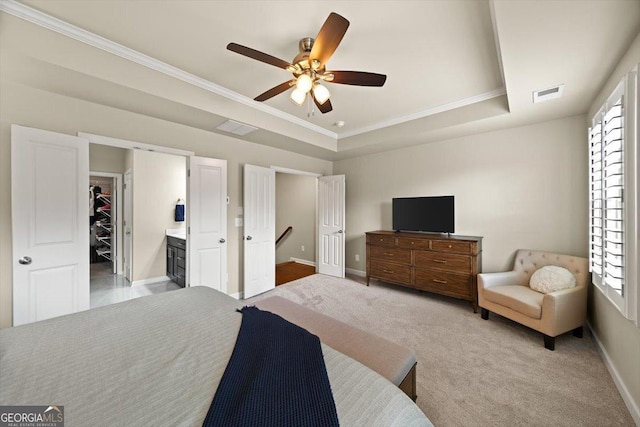 bedroom with crown molding, a spacious closet, ceiling fan, a raised ceiling, and light colored carpet