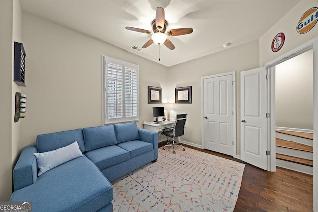 home office with dark hardwood / wood-style flooring and ceiling fan