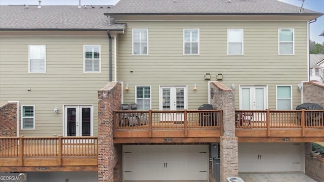 rear view of property with a garage and french doors