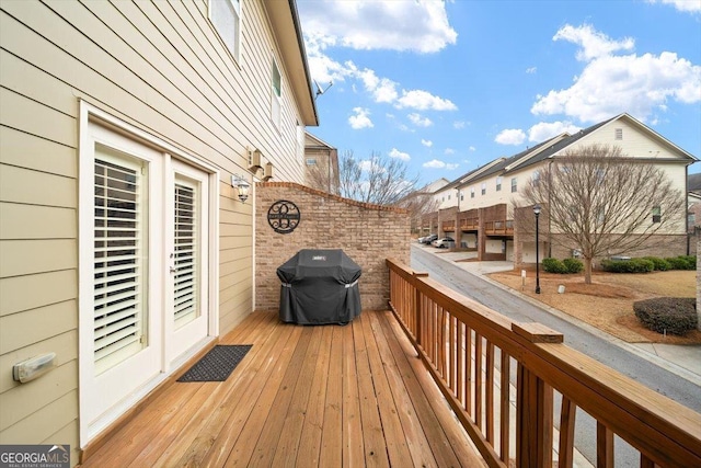 wooden deck featuring a grill