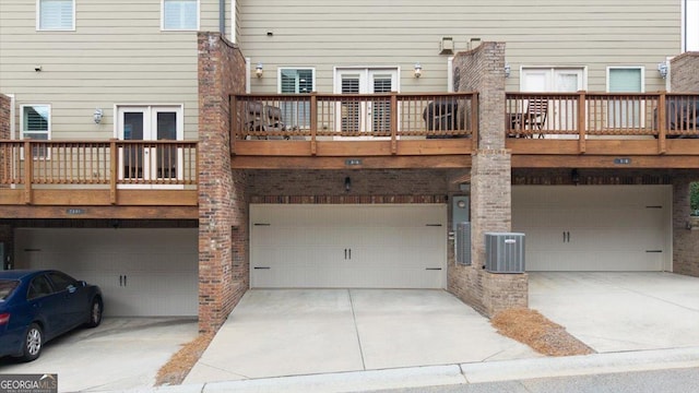 back of property with a garage, cooling unit, and french doors