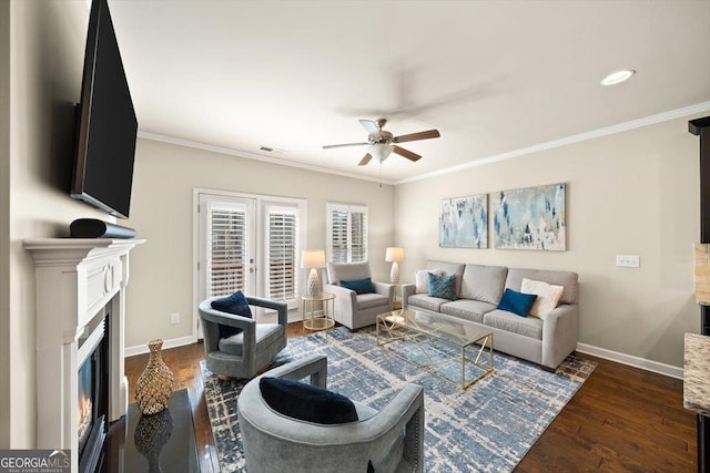 living room featuring dark wood-type flooring, ornamental molding, and ceiling fan