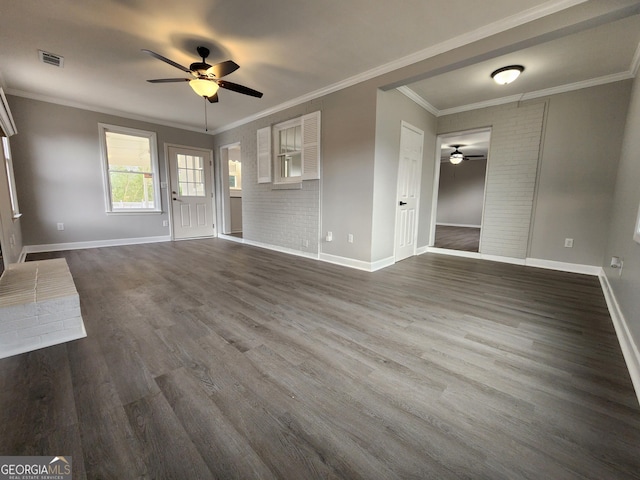 unfurnished living room with crown molding, dark wood-type flooring, ceiling fan, and brick wall