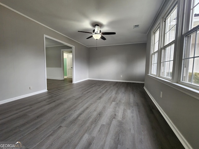 unfurnished room featuring dark hardwood / wood-style flooring, ornamental molding, and ceiling fan