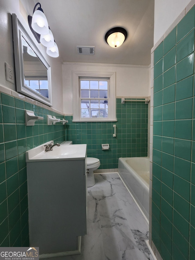 bathroom featuring vanity, a bathing tub, a healthy amount of sunlight, and toilet