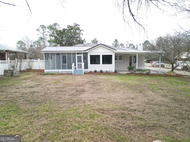 view of front of property with a carport, a sunroom, and a front yard