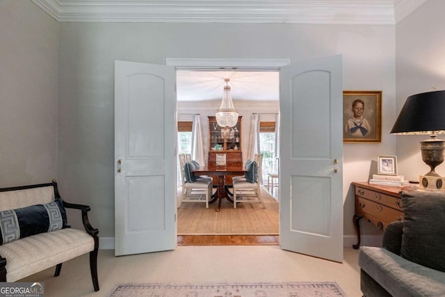 living area with ornamental molding and an inviting chandelier