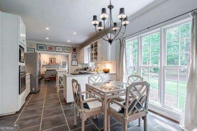 tiled dining room featuring a notable chandelier, ornamental molding, and sink