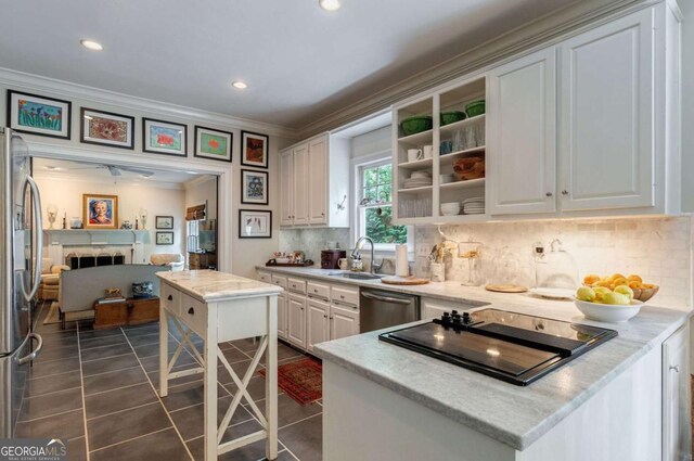 kitchen with appliances with stainless steel finishes, sink, white cabinets, dark tile patterned floors, and ornamental molding