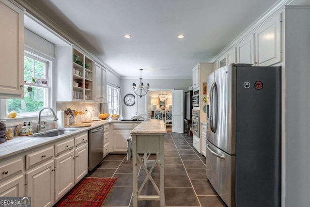 kitchen with pendant lighting, sink, white cabinets, and appliances with stainless steel finishes