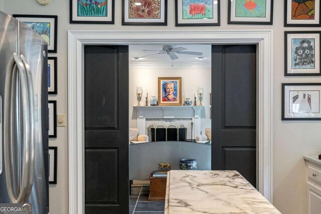 interior space with vanity, a fireplace, ornamental molding, and ceiling fan