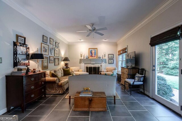 living room with ceiling fan, ornamental molding, and dark tile patterned floors