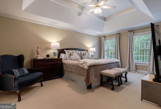 carpeted bedroom with crown molding, a tray ceiling, and ceiling fan