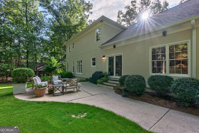 back of house featuring a lawn and a patio