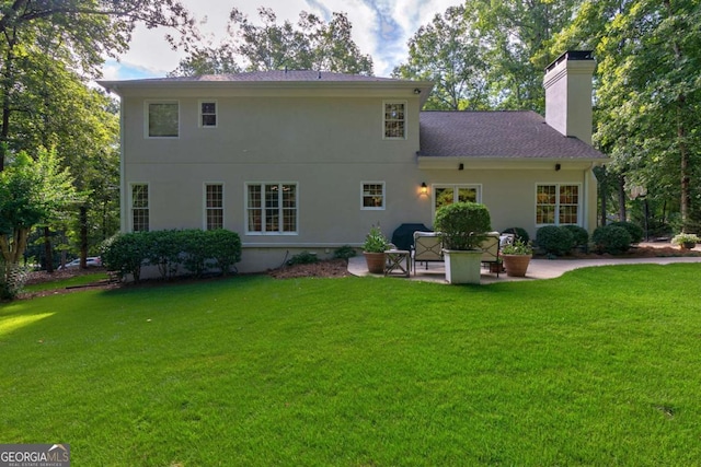 rear view of house with a yard and a patio