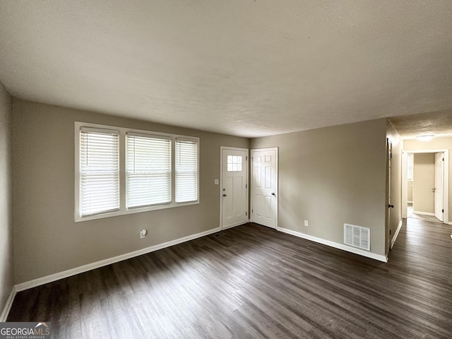 foyer entrance featuring dark wood-type flooring and a textured ceiling