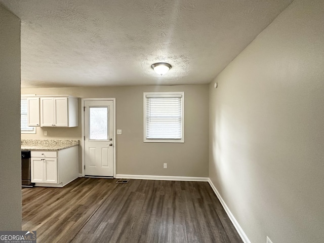 kitchen with white cabinetry, dark wood-type flooring, dishwashing machine, and a textured ceiling