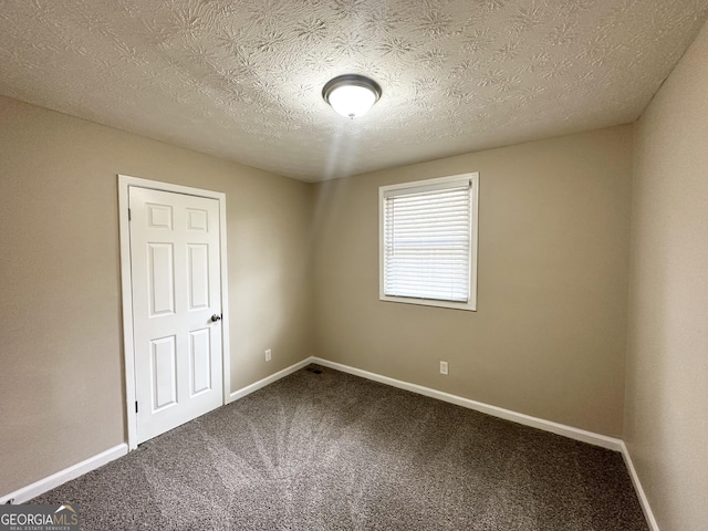 carpeted spare room featuring a textured ceiling